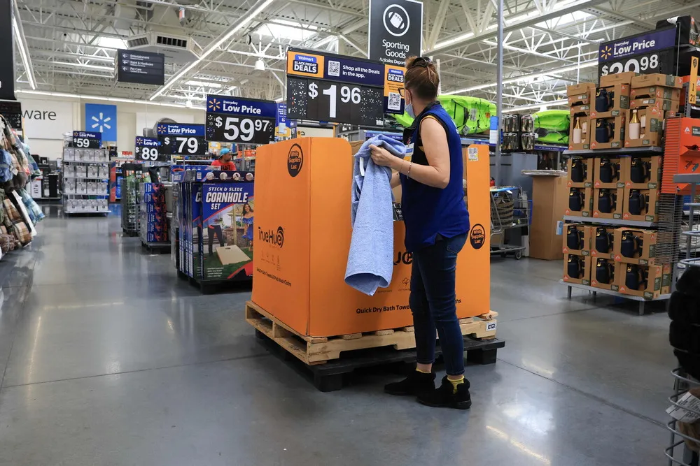 Walmart store employee folding towels on a sales floor