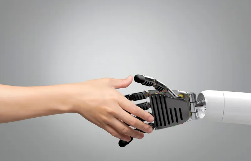 A human hand shaking a robotic hand