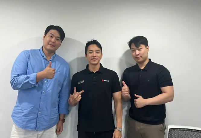 Three people posing together in an office