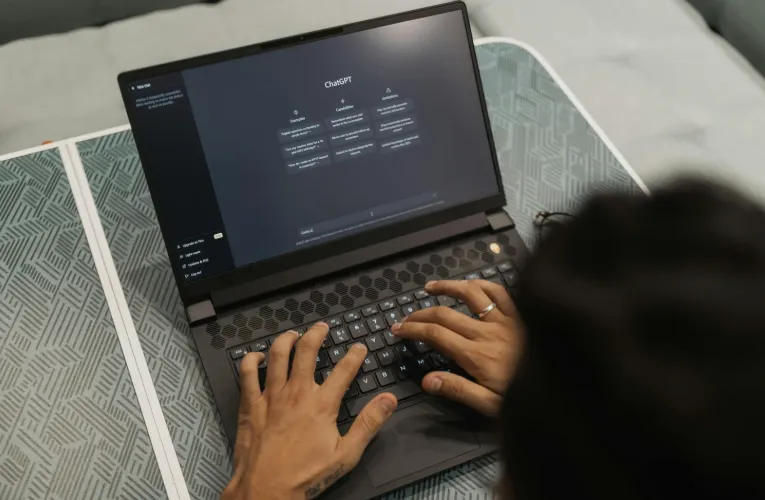 Person typing on a laptop with ChatGPT open