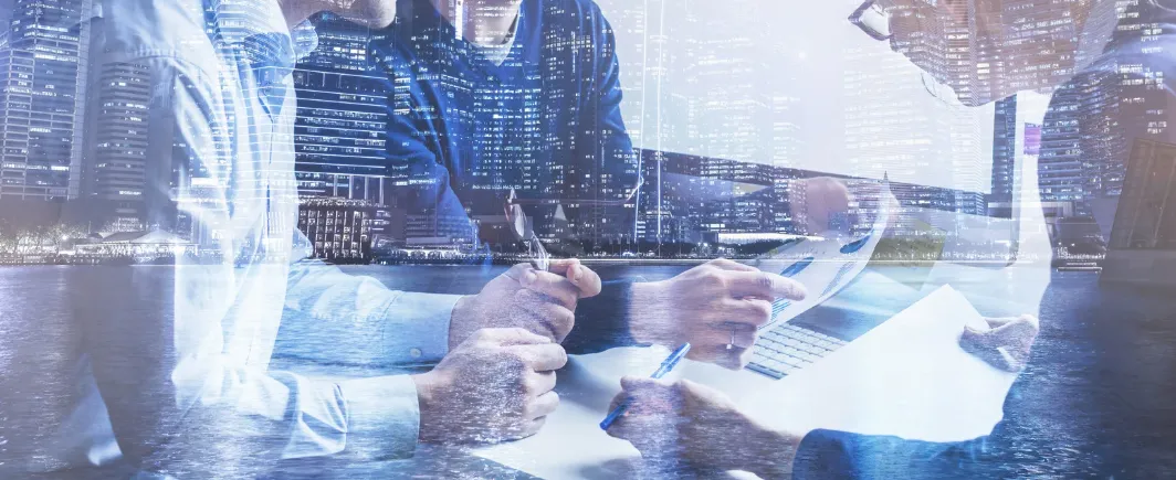 Business people reviewing documents against a city skyline