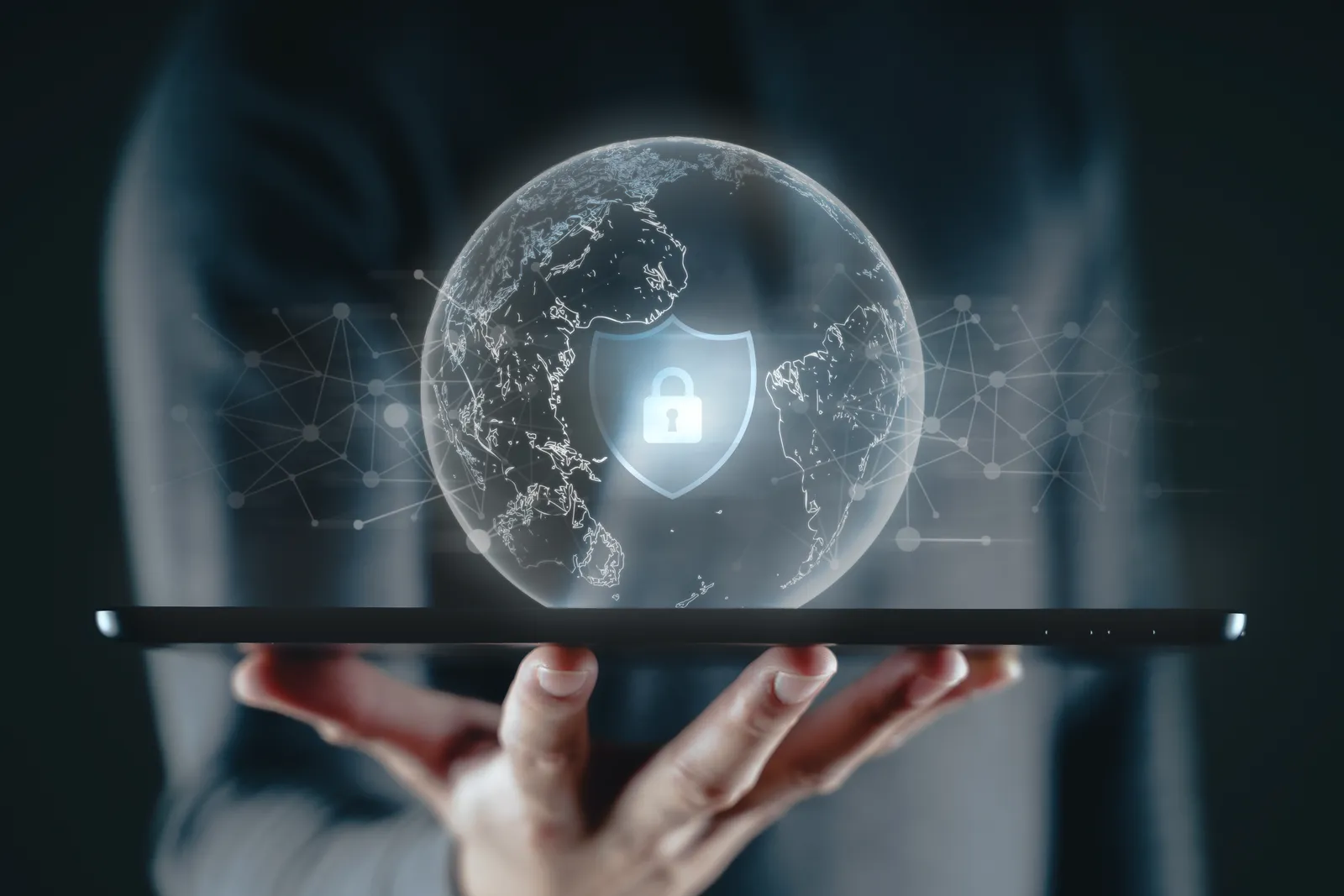 Hand holding a tablet with a globe and a shield-and-lock icon